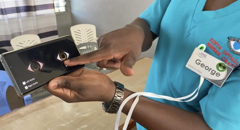 A Kenyan Ophthalmology clinician pointing to a phone displaying our game